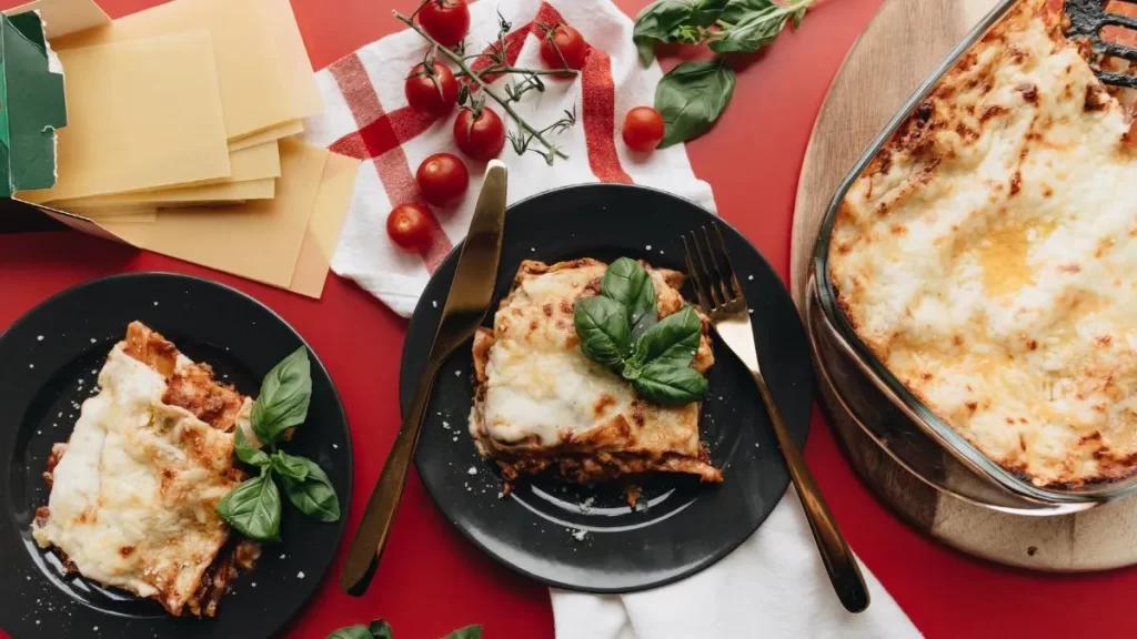 Restaurant la moutonne - photo d'une belle table avec des plat et une assiette de lasagne sur un nappe rouge et blanche